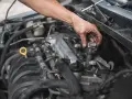 Mechanik wymienia cewkę zapłonową, co może być rozwiązaniem problemów z nierówną pracą silnika.
