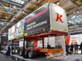 Nowa naczepa Kässbohrer z napisem "Pioneering Trailer Engineering". W tle ludzie zwiedzają targi.