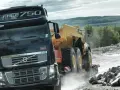 Ciężarówka Volvo FH16 750 z naczepą przewozi żółty wozidło przegubowe przez kamieniołom.