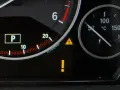 Na desce rozdzielczej świeci się kontrolka żółty wykrzyknik w trójkącie, sygnalizując problem. Obok wskaźnik temperatury oleju.