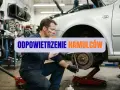 Mechanik w warsztacie wykonuje odpowietrzanie hamulców w samochodzie, dbając o bezpieczeństwo jazdy.