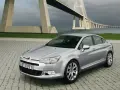 Srebrny Citroen C5 na tle mostu. Wiele osób chwali ten model, a opinie o Citroen C5 są zazwyczaj pozytywne.