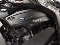 Silnik BMW TwinPower Turbo, prawdopodobnie 2.0 diesel, z widocznym logo BMW i elementami osprzętu.