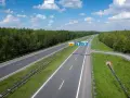 Znaki na autostradzie A4 informują, czy jest ona płatna. Widok na pustą autostradę w słoneczny dzień.