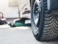 Zimowa opona na feldze, obok podnośnika. Właściwy kierunek montażu opon to klucz do bezpieczeństwa.