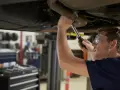 Mechanik naprawia układ wydechowy Renault, być może z powodu błędu DTC P0420.