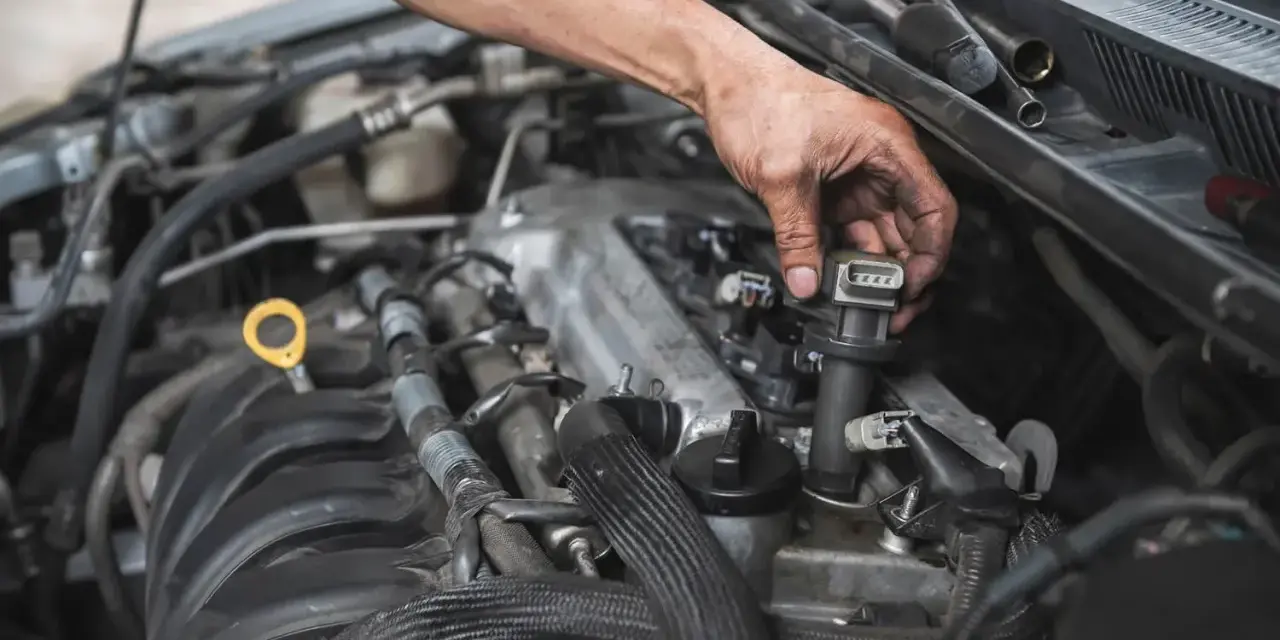 Mechanik wymienia cewkę zapłonową, co może być rozwiązaniem problemów z nierówną pracą silnika.