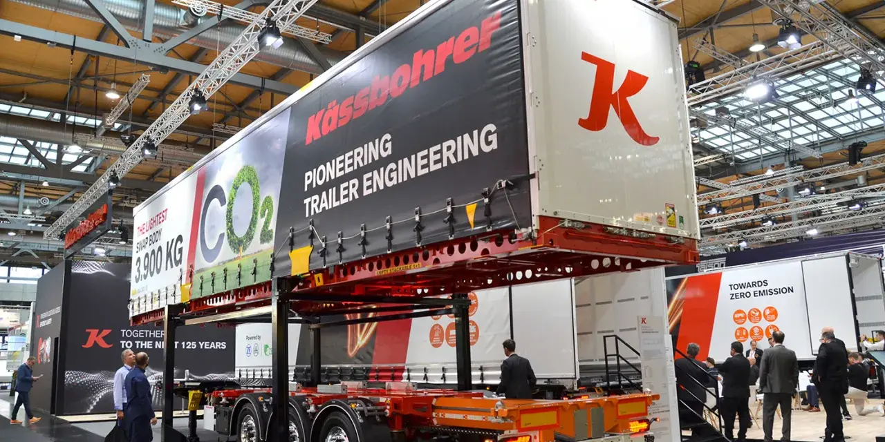 Nowa naczepa Kässbohrer z napisem "Pioneering Trailer Engineering". W tle ludzie zwiedzają targi.