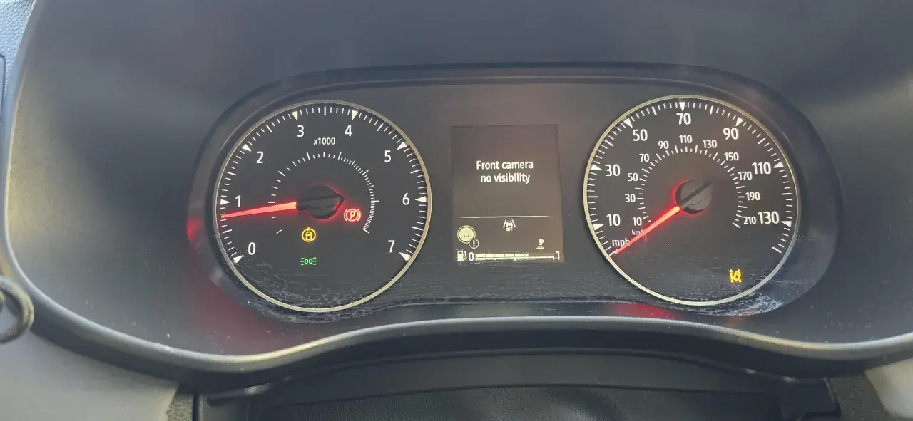 Dacia Sandero: kontrolki informują o braku widoczności kamery przedniej. Widoczne kontrolki hamulca ręcznego, ABS i ciśnienia w oponach.