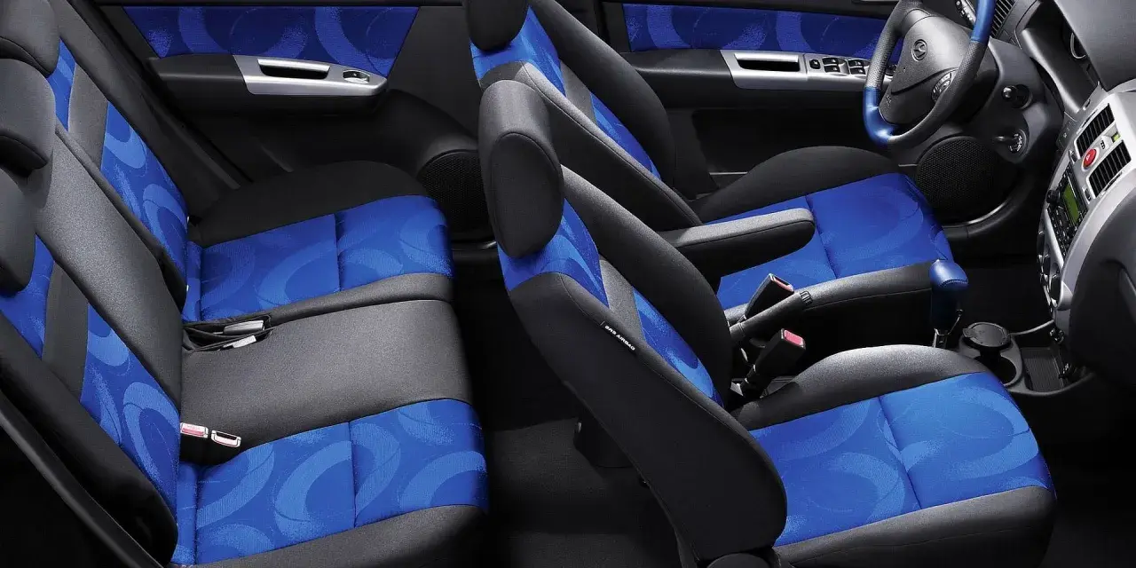 Wnętrze Hyundai Getz z niebiesko-szarymi siedzeniami i niebieskimi akcentami na drzwiach.