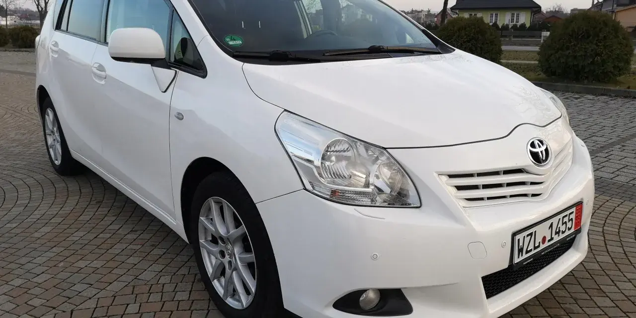 Biała Toyota Verso 1.8 benzyna zaparkowana na kostce brukowej.