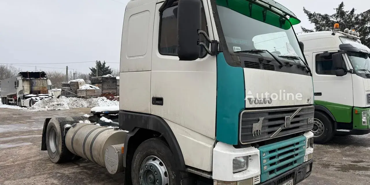 Ciężarówka Volvo FH12 z zielonym akcentem na kabinie, zaparkowana na zewnątrz w zimowy dzień.