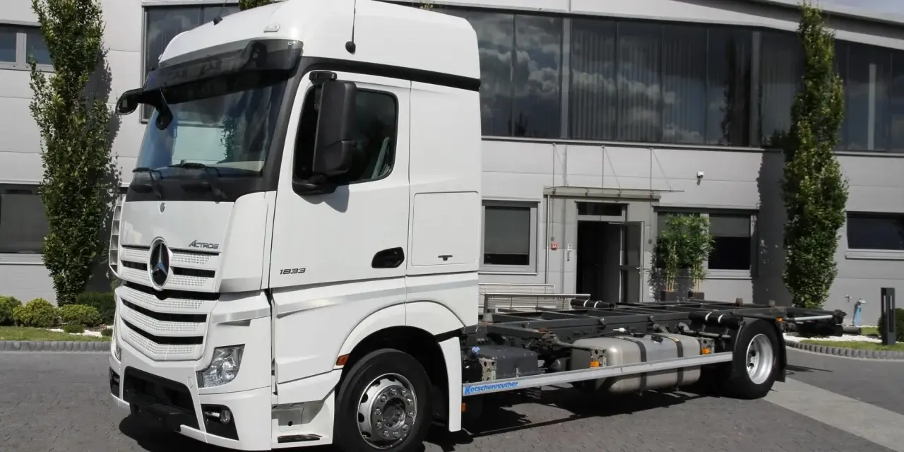 Biały Mercedes Actros MP4 z systemem hakowym, gotowy do pracy.