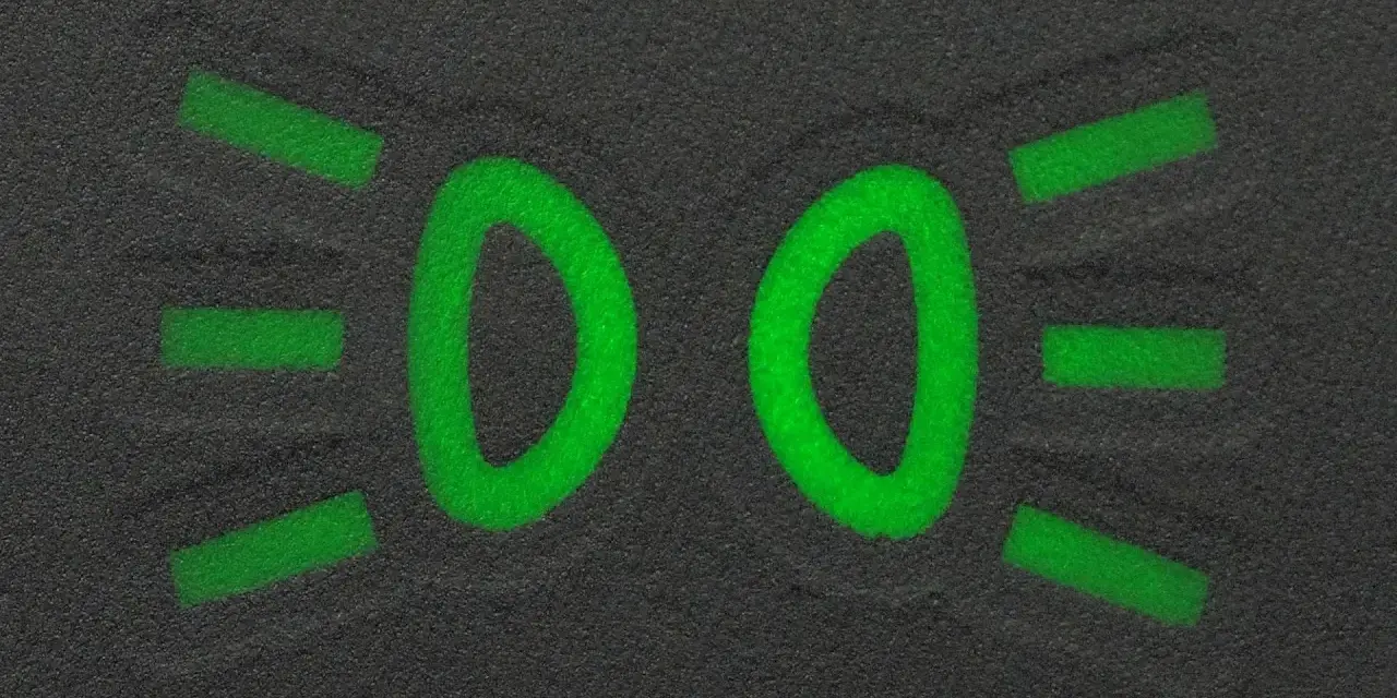 Zielony symbol świateł mijania na ciemnym tle.