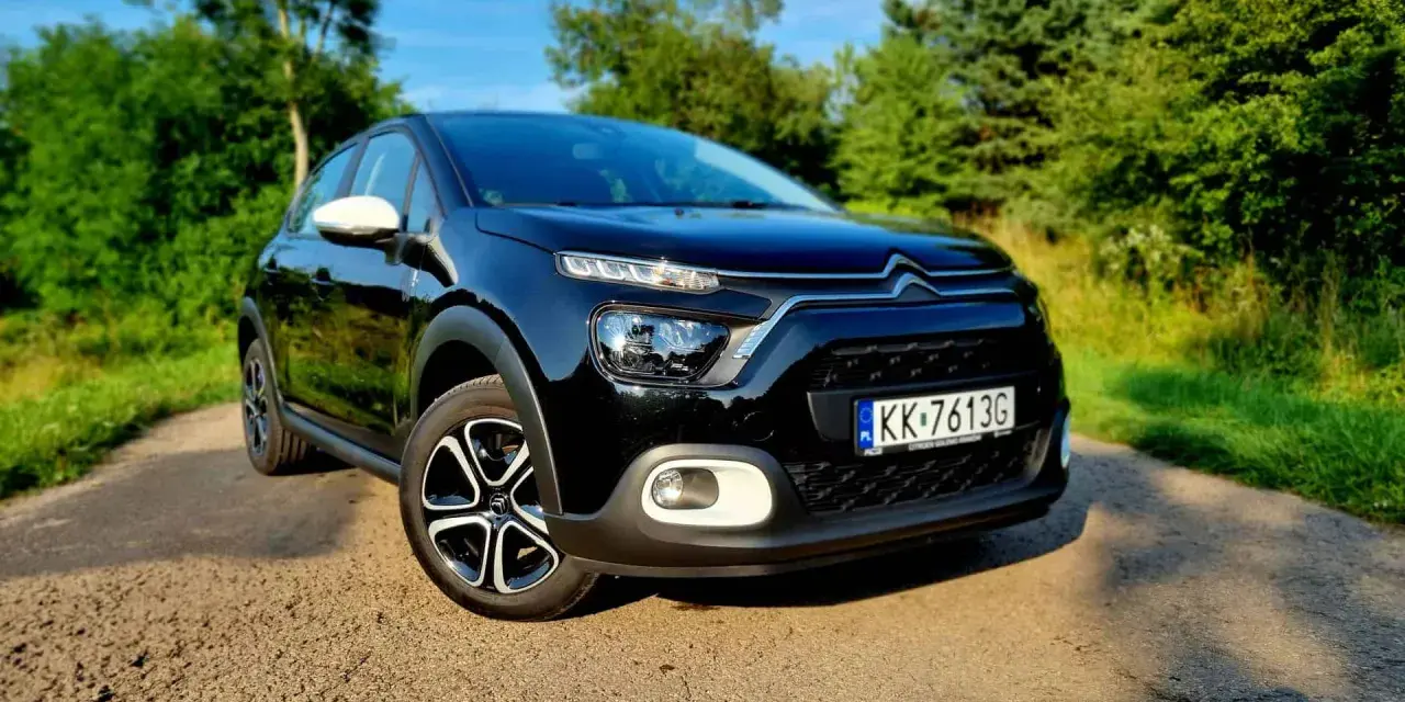 Czarny Citroen C3 na tle zieleni. Sprawdź atrakcyjną citroen c3 cena i wybierz swój wymarzony samochód.