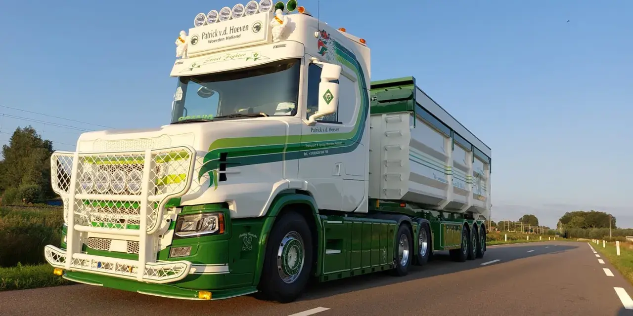 Biała Scania T z zielonymi pasami i napisem "Street Fighter" na tle błękitnego nieba.
