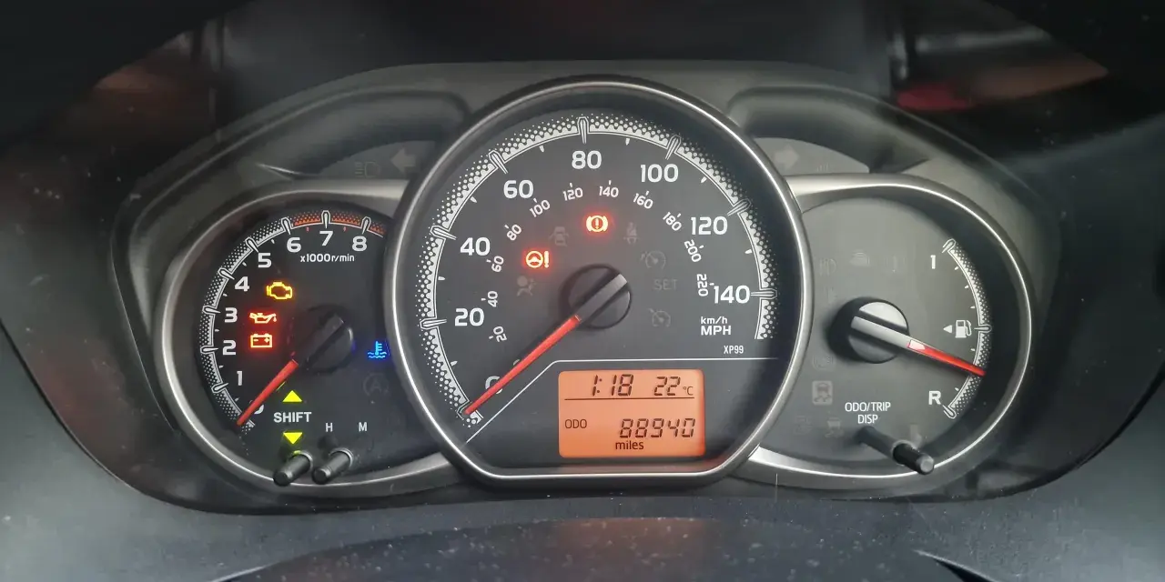 Kontrolka silnika świeci się na desce rozdzielczej Toyoty, wskazując błąd DTC P1604. Oprócz tego widoczne są kontrolki oleju, akumulatora i temperatury.
