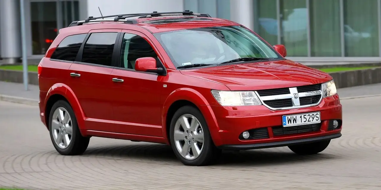 Czerwony Dodge Journey w ruchu. Wiele osób szuka dodge journey opinie przed zakupem.