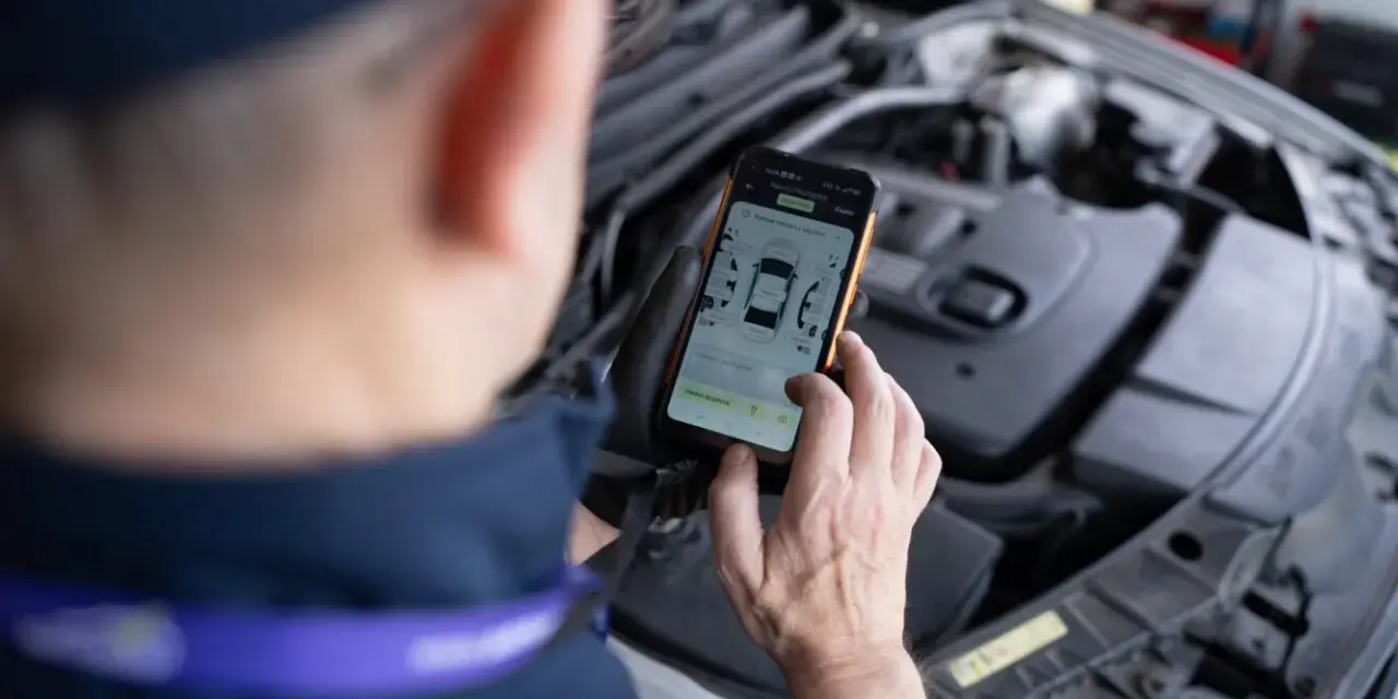 Mechanik sprawdza DTC BMW na smartfonie, analizując dane z silnika.