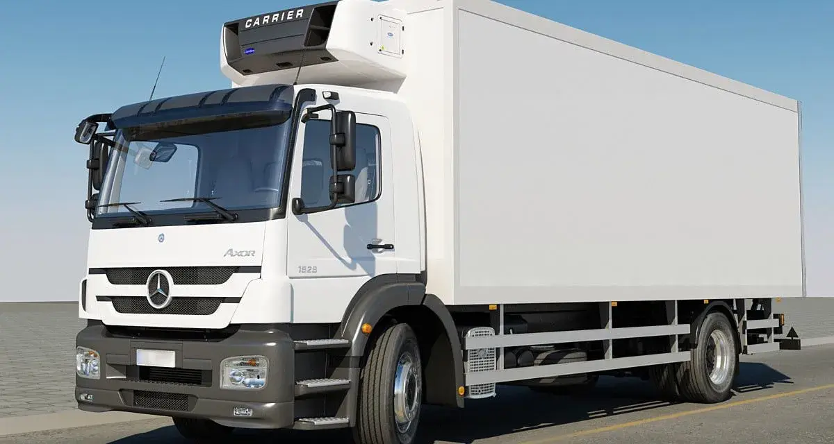 Biała chłodnia Mercedes Axor z agregatem Carrier na dachu, gotowa do transportu towarów.