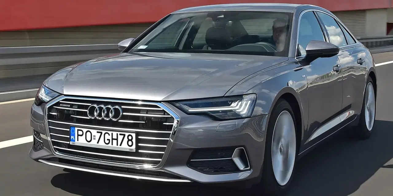 Szary Audi A6 na drodze. Sprawdź aktualną audi a6 cena i wyposażenie.