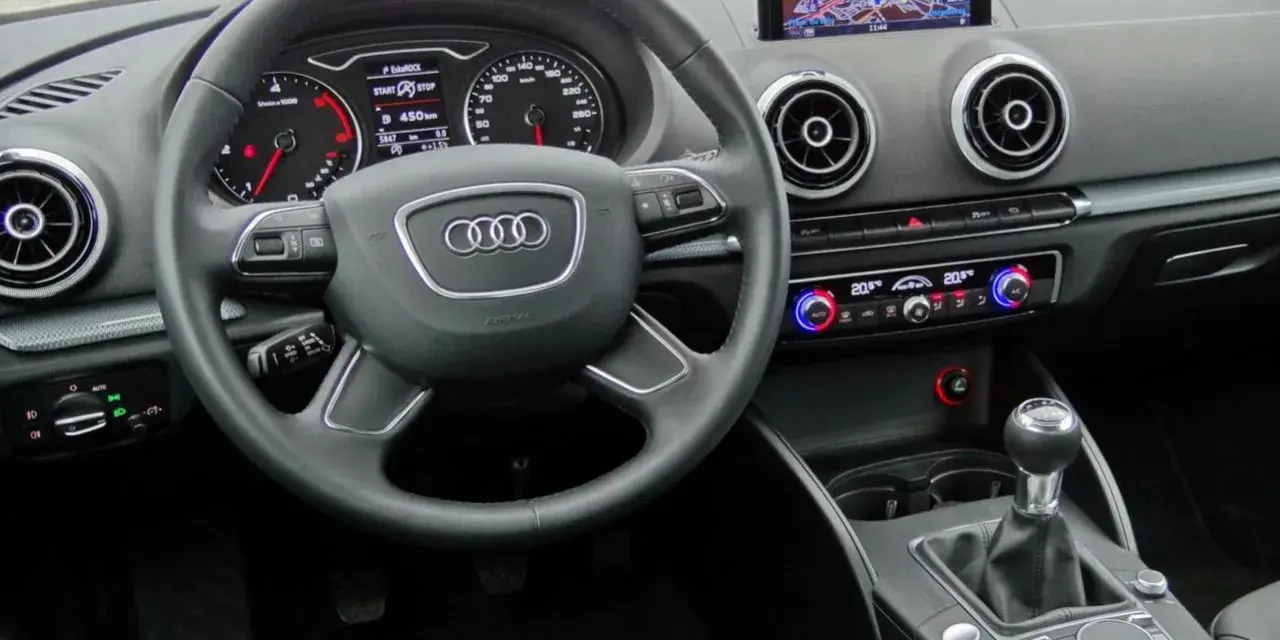 Wnętrze Audi A3 kombi: kierownica, nawigacja, panel klimatyzacji i skrzynia biegów.