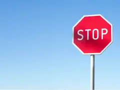 Czerwony znak STOP na tle błękitnego nieba. Uważaj, by nie dostać mandatu za stop!