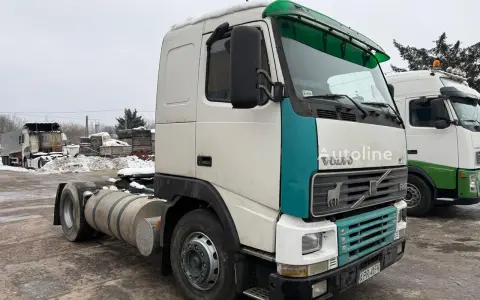 Ciężarówka Volvo FH12 z zielonym akcentem na kabinie, zaparkowana na zewnątrz w zimowy dzień.