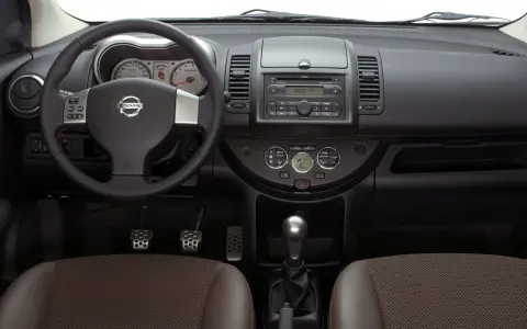 Wnętrze Nissan Note E11: kierownica, deska rozdzielcza z radiem i zegarami, dźwignia zmiany biegów, fotele.