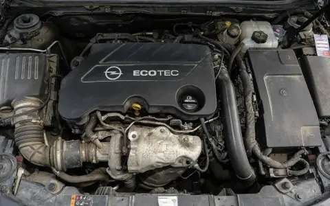 Silnik Opel Ecotec. Widoczne elementy układu dolotowego i turbosprężarki. Objawy uszkodzenia poduszki silnika mogą być różne, np. wibracje.