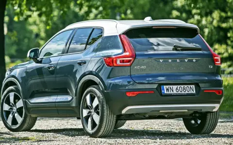 Tylna część ciemnoszarego Volvo XC40 z białym dachem, zaparkowanego na żwirowej drodze. Sprawdź aktualną volvo xc40 cena.
