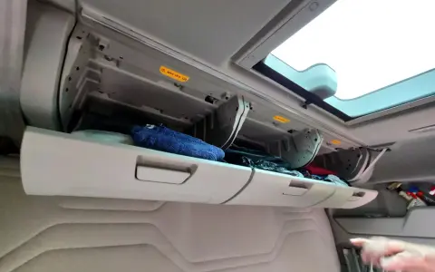 Schowek w kabinie Ford F-Max z niebieskim ręcznikiem i innymi przedmiotami.