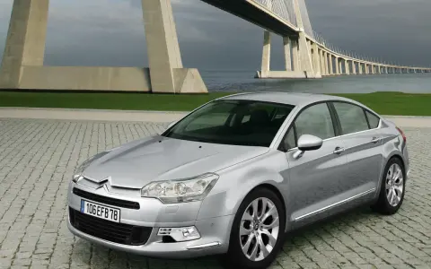 Srebrny Citroen C5 na tle mostu. Wiele osób chwali ten model, a opinie o Citroen C5 są zazwyczaj pozytywne.
