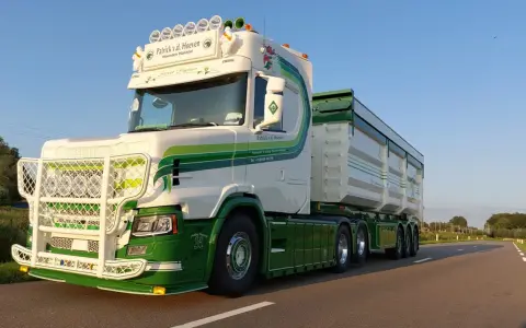Biała Scania T z zielonymi pasami i napisem "Street Fighter" na tle błękitnego nieba.
