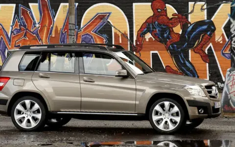 Brązowy suv Mercedes GLK na tle kolorowego graffiti z Spider-Manem.