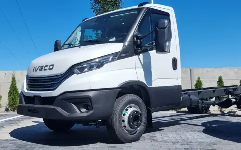 Biały Iveco 70C18, podwozie gotowe do zabudowy, stoi na placu z kostki brukowej.