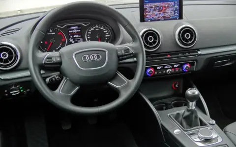 Wnętrze Audi A3 kombi: kierownica, nawigacja, panel klimatyzacji i skrzynia biegów.