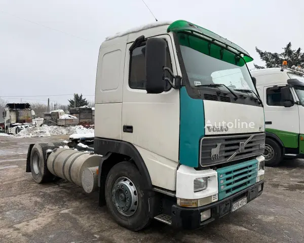 Ciężarówka Volvo FH12 z zielonym akcentem na kabinie, zaparkowana na zewnątrz w zimowy dzień.