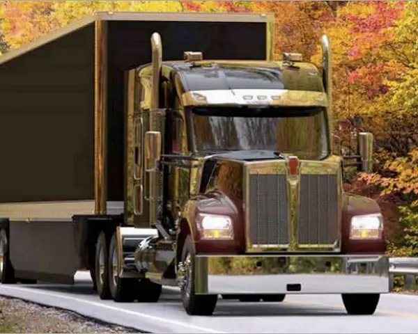 Błyszczący Kenworth W900 z przyczepą jedzie drogą wśród jesiennych drzew.