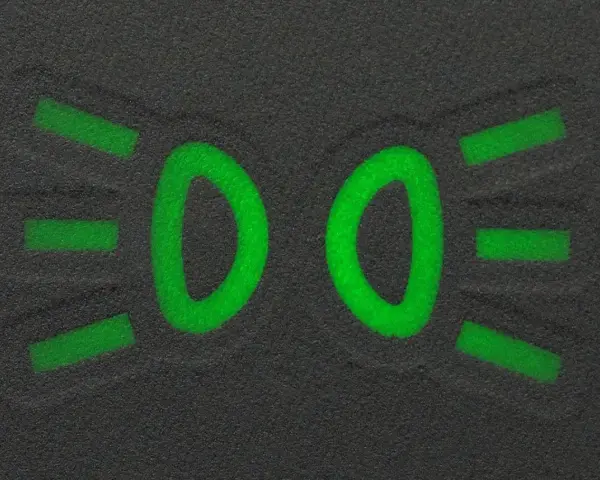 Zielony symbol świateł mijania na ciemnym tle.