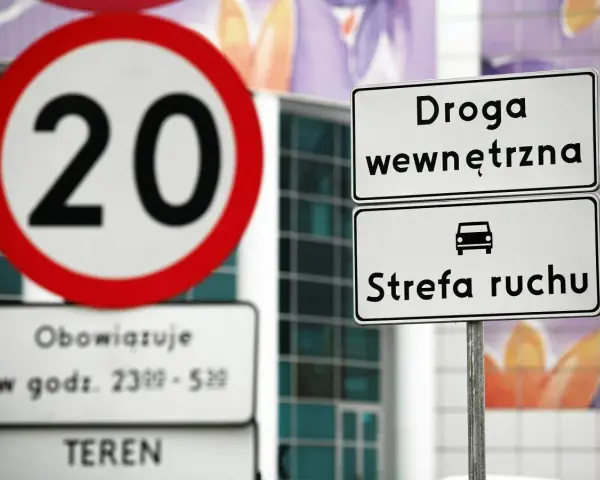 Znak ograniczenia prędkości do 20 km/h i tablica informująca o wjeździe do strefy ruchu.
