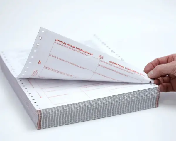 Stos papierów z nadrukiem "CMR" i "INTERNATIONAL CONSIGNMENT NOTE". Dokumenty te służą do międzynarodowego przewozu towarów.