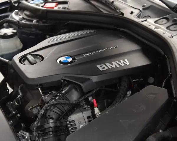 Silnik BMW TwinPower Turbo, prawdopodobnie 2.0 diesel, z widocznym logo BMW i elementami osprzętu.