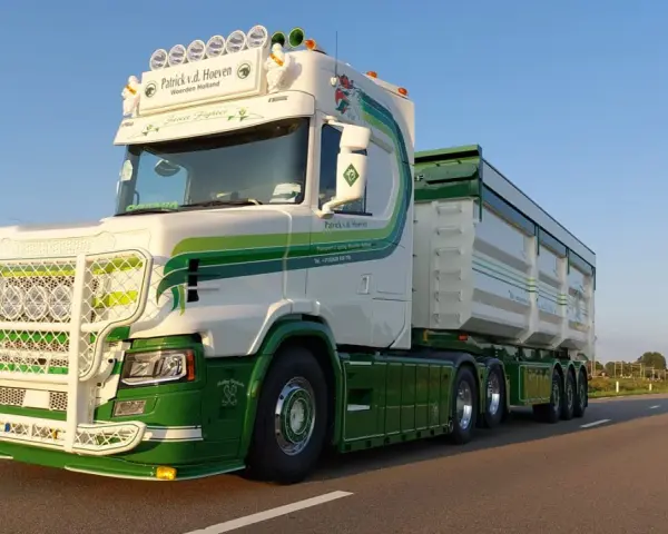 Biała Scania T z zielonymi pasami i napisem "Street Fighter" na tle błękitnego nieba.