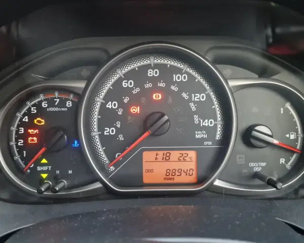 Kontrolka silnika świeci się na desce rozdzielczej Toyoty, wskazując błąd DTC P1604. Oprócz tego widoczne są kontrolki oleju, akumulatora i temperatury.
