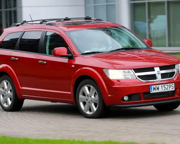Czerwony Dodge Journey w ruchu. Wiele osób szuka dodge journey opinie przed zakupem.