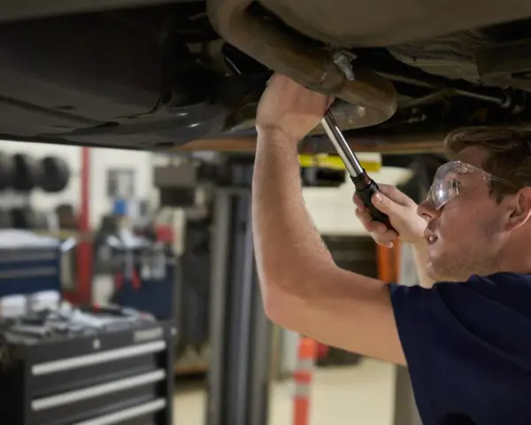 Mechanik naprawia układ wydechowy Renault, być może z powodu błędu DTC P0420.