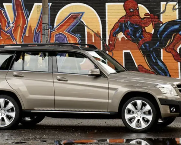 Brązowy suv Mercedes GLK na tle kolorowego graffiti z Spider-Manem.