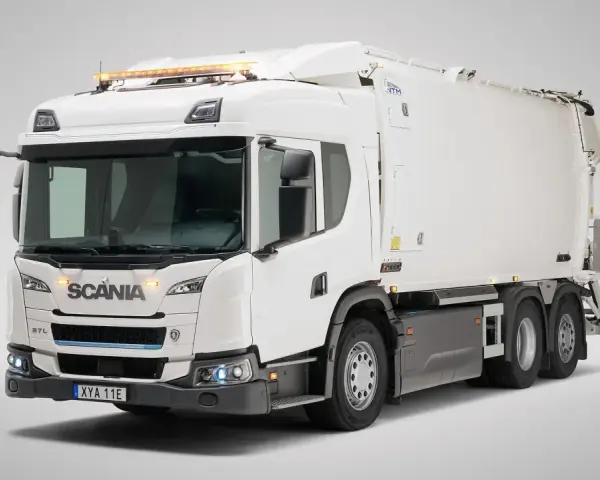 Biała śmieciarka Scania Streamline z niebieskim akcentem na grillu i pomarańczowymi światłami ostrzegawczymi na dachu.