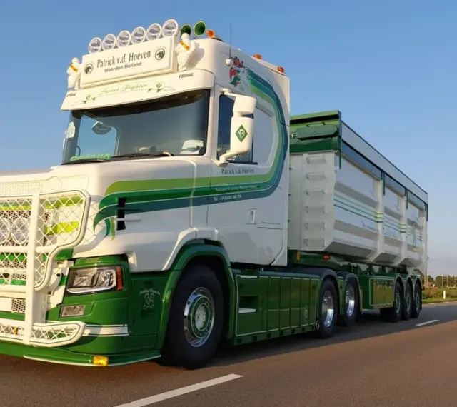 Biała Scania T z zielonymi pasami i napisem "Street Fighter" na tle błękitnego nieba.